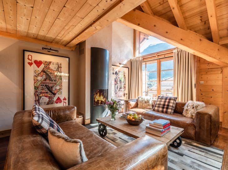 Morzine Property management A living room with a fireplace and wooden beams.