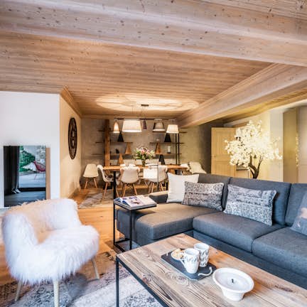 A living room with wooden ceilings and a couch.