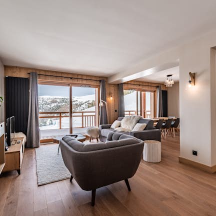 Apartment Fagus A living room with wood floors and a view of the mountains.