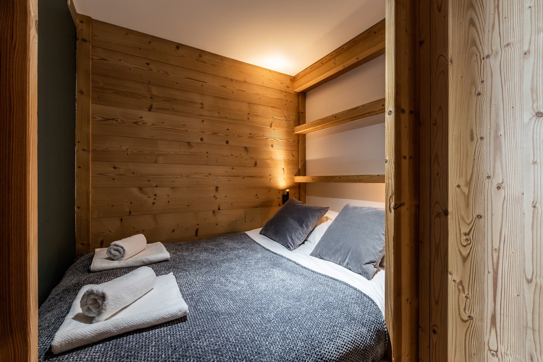 Chambre 3 avec lit double et murs en bois à la location Wapa à l'Alpe d'Huez