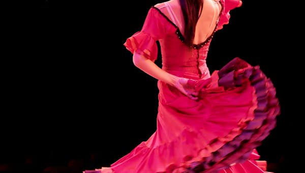 A woman in a red dress dancing on stage