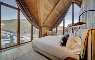Baqueira Beret accommodation - Chalet Timok  - A bedroom with large windows overlooking a mountain.