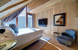 Baqueira Beret accommodation - Chalet Enza - A bedroom with wooden walls and a bed.