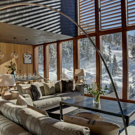 A living room with large windows overlooking a snowy mountain.