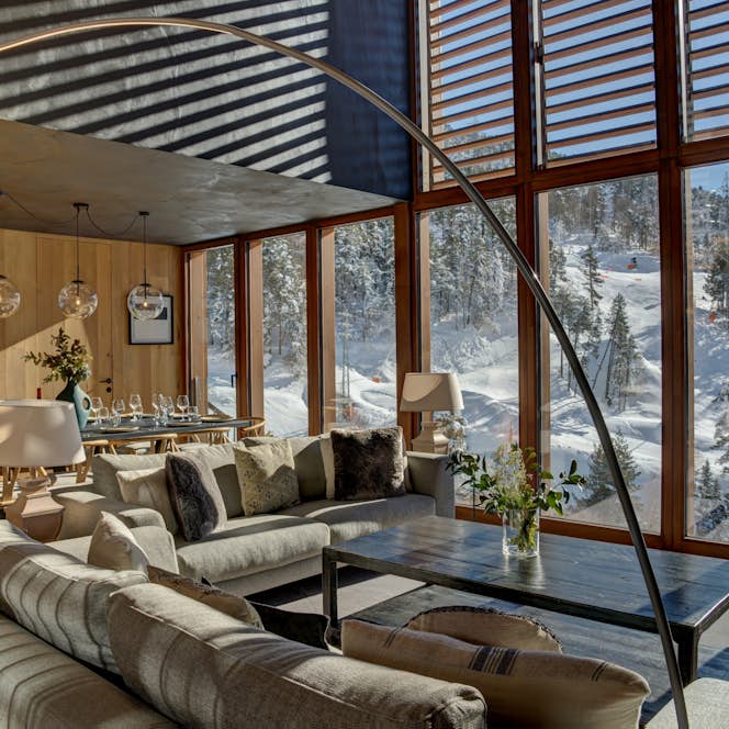 Baqueira Beret accommodation - Chalet Enza - A living room with large windows overlooking a snowy mountain.