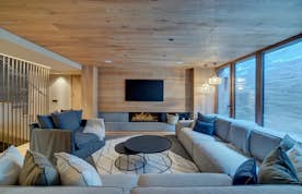 Baqueira Beret location - Chalet Timok  - A living room with wood walls and a fireplace.