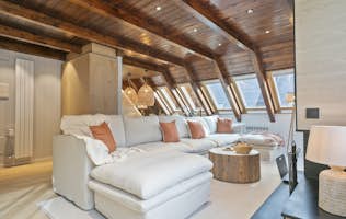 Val de Ruda - 2 Baqueira Beret accommodation - Apartment Nevada - A contemporary living room with two large sofas, round poufs, a wooden coffee table, large windows with mountain views, and a corner fireplace.