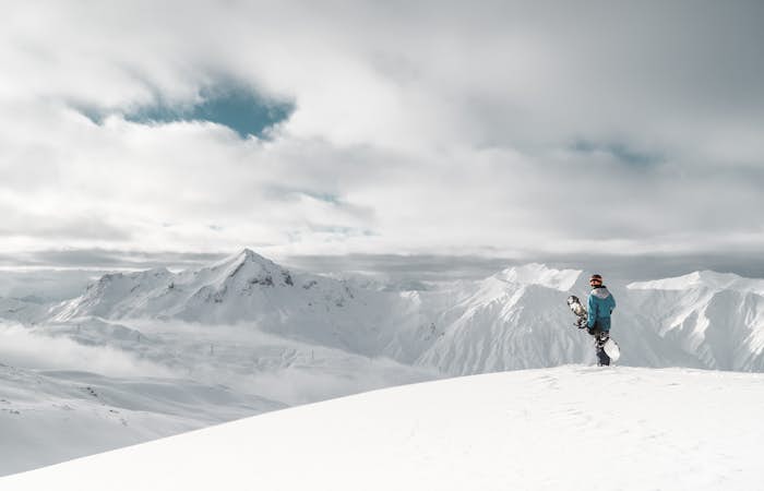 A person standing on top of a snow covered mountain