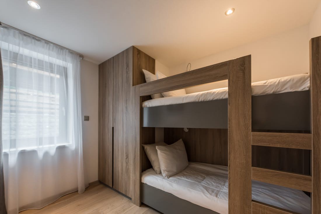 Morzine location - Appartement Ipê - Une chambre avec lits superposés moderne avec une salle de bain dans l'appartement services hôteliers Ipê à Morzine