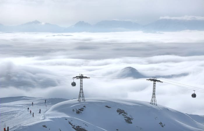 Gondolas and skiers on a snow covered mountain.
