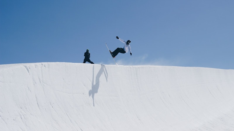 Skier jumping over snow dune on skiing holiday in French Alps Skier jumping over snow dune on skiing holiday in French Alps