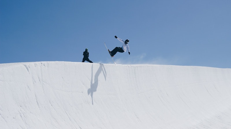 Skier jumping over snow dune on skiing holiday in French Alps