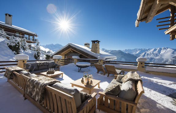 The terrace of a ski chalet with a view of the mountains.