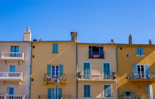 A person swimming freestyle in a calm sea with mountains visible in the distant haze.