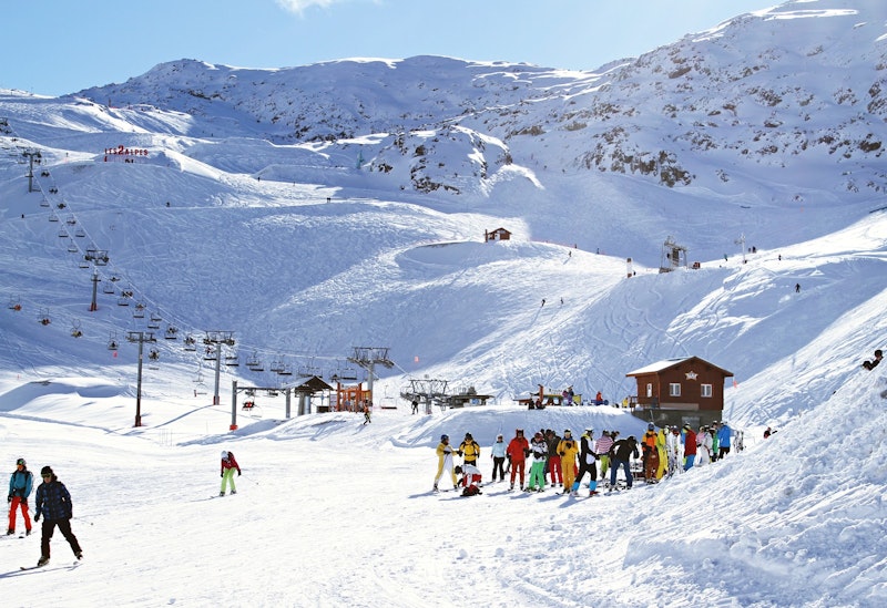Group of skiers at the bottom of a slope during ski holidays in French Alps