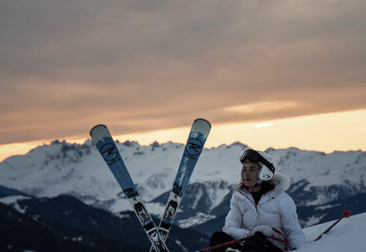 Une dame en tenue d'hiver skiant rapidement dans la neige aux Arcs