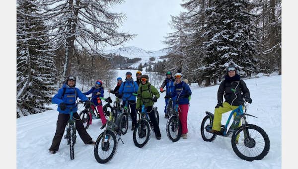 Deux personnes s'adonnant à l'activité motoneige électrique aux Arcs  Un père guidant son fils sur l'activité de motoneige électrique aux Arcs